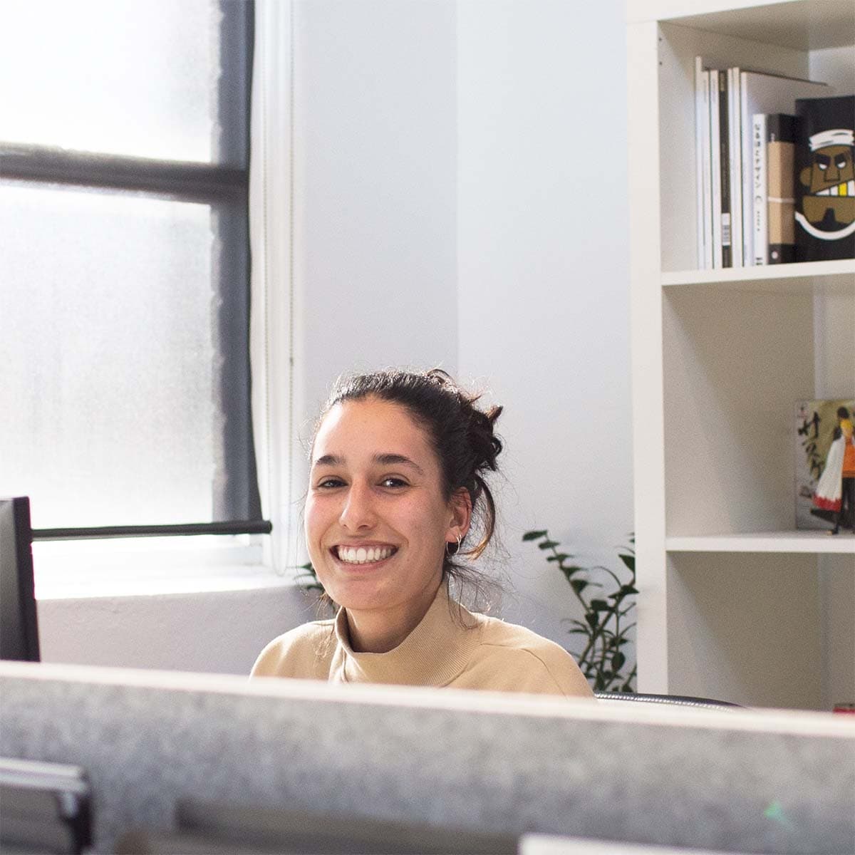 A woman smiles at her office desk