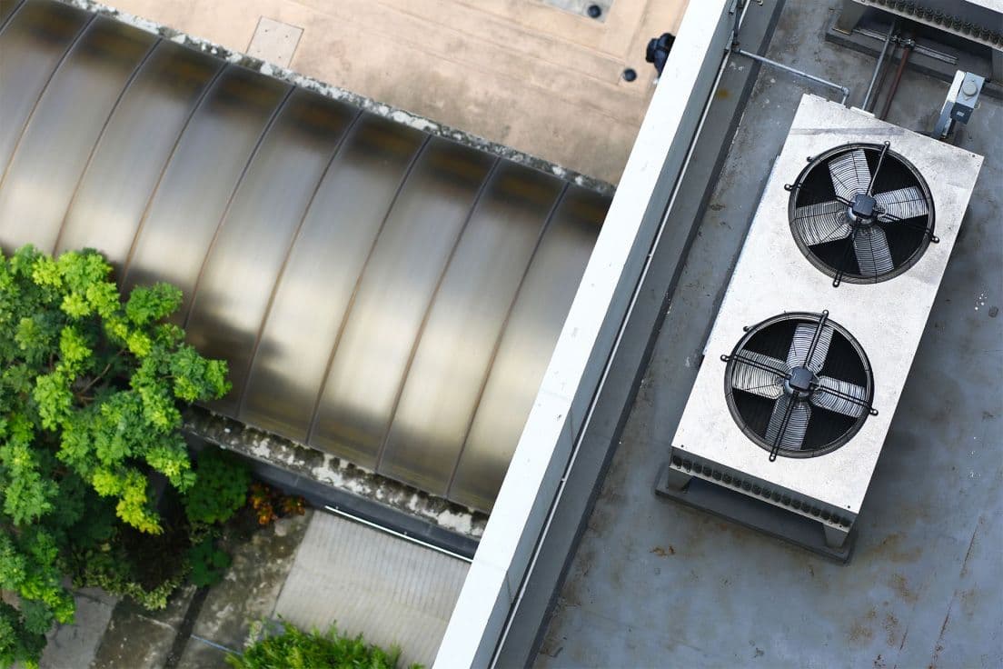Birds-eye view of industrial fan vent on a rooftop.